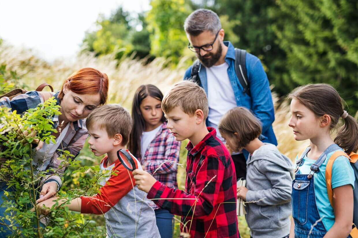 Children and teacher doing research outdoors